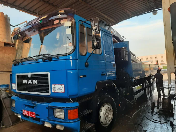 Workshop support with blue heavy vehicle in the yard